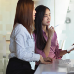Small business owner in Singapore discussing content strategy with an instructor during an in-person AI course