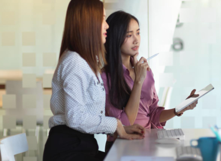 Small business owner in Singapore discussing content strategy with an instructor during an in-person AI course