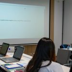 AI content creation training Singapore trainer guiding a learner through an AI design tool in class